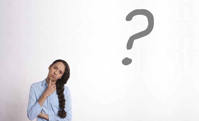 FAQ budgeting notes and question marks on paper